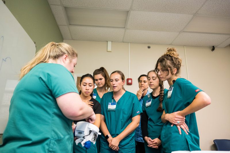 A group of Virginia Tech MSND students stand together in a group to observe a demonstration by a Carilion Clinic Registered Dietitian